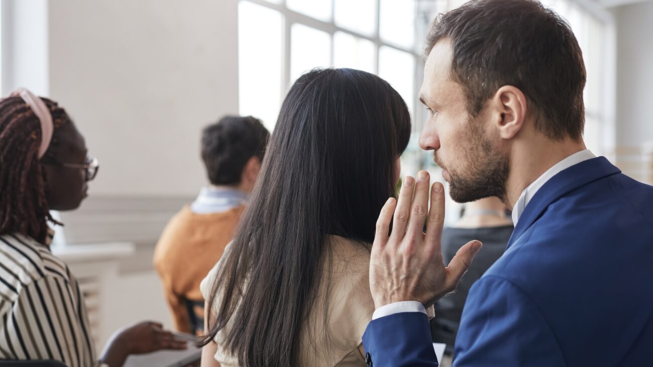 Man whispering in lady’s ear