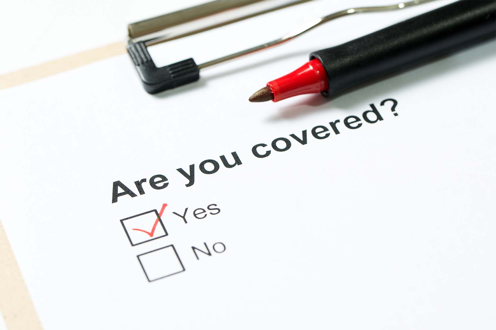 Are you covered by homeowners insurance questionnaire on clipboard with a red pen