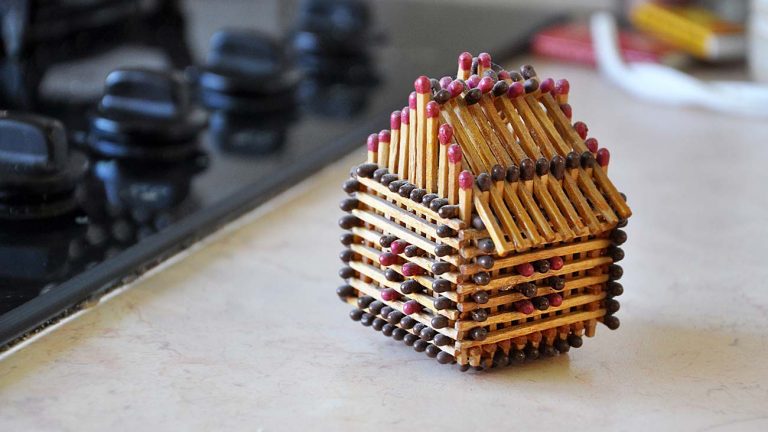 Concept art of a house made out of matches illustrates the fire damage insurance claims process
