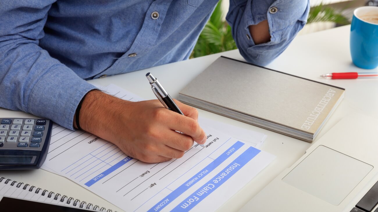 Man filling out an insurance claim form