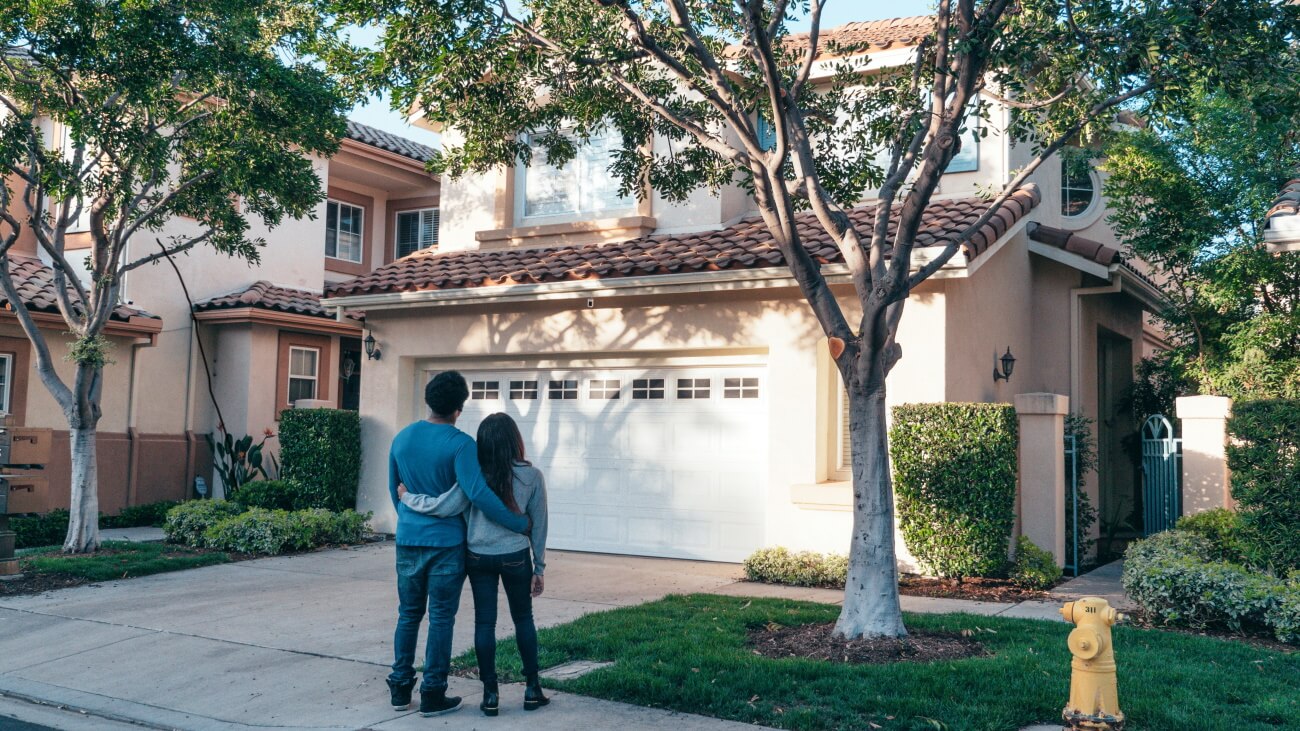 Couple standing in front of their house