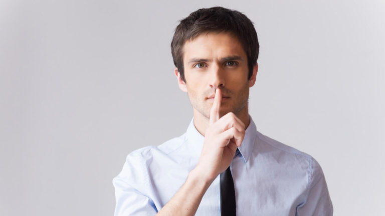 Man holding finger on lips showing someone not to say anything