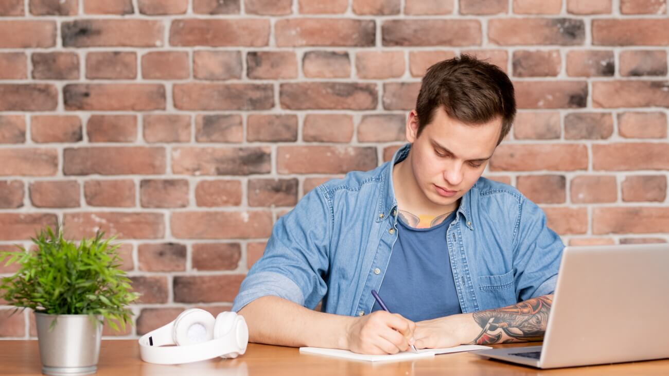 Man sitting in front of laptop making a home inventory list