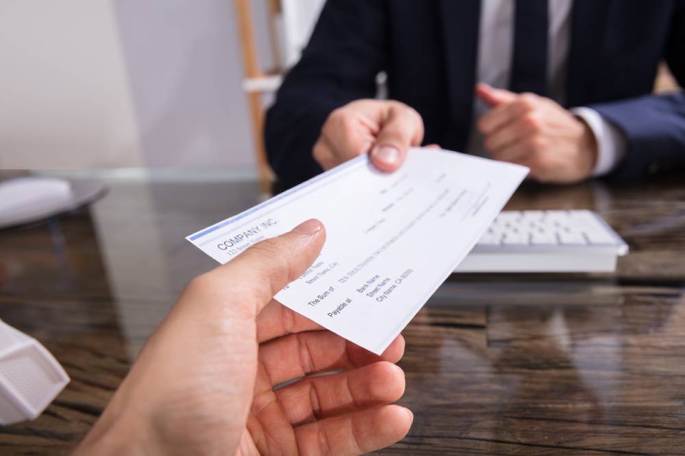 Person being handed a check