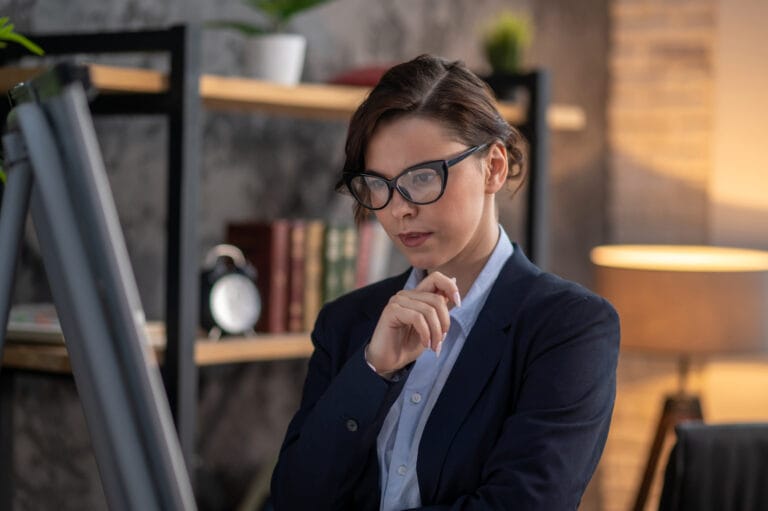 Thoughtful female public adjuster in los angeles in black glasses