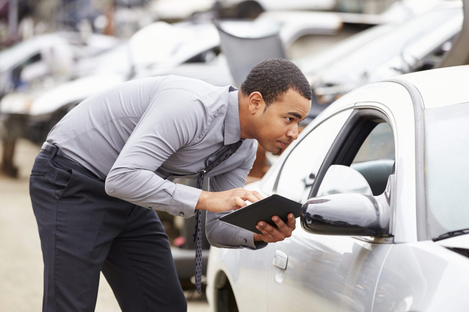 Young male public adjuster in los angeles checking the car