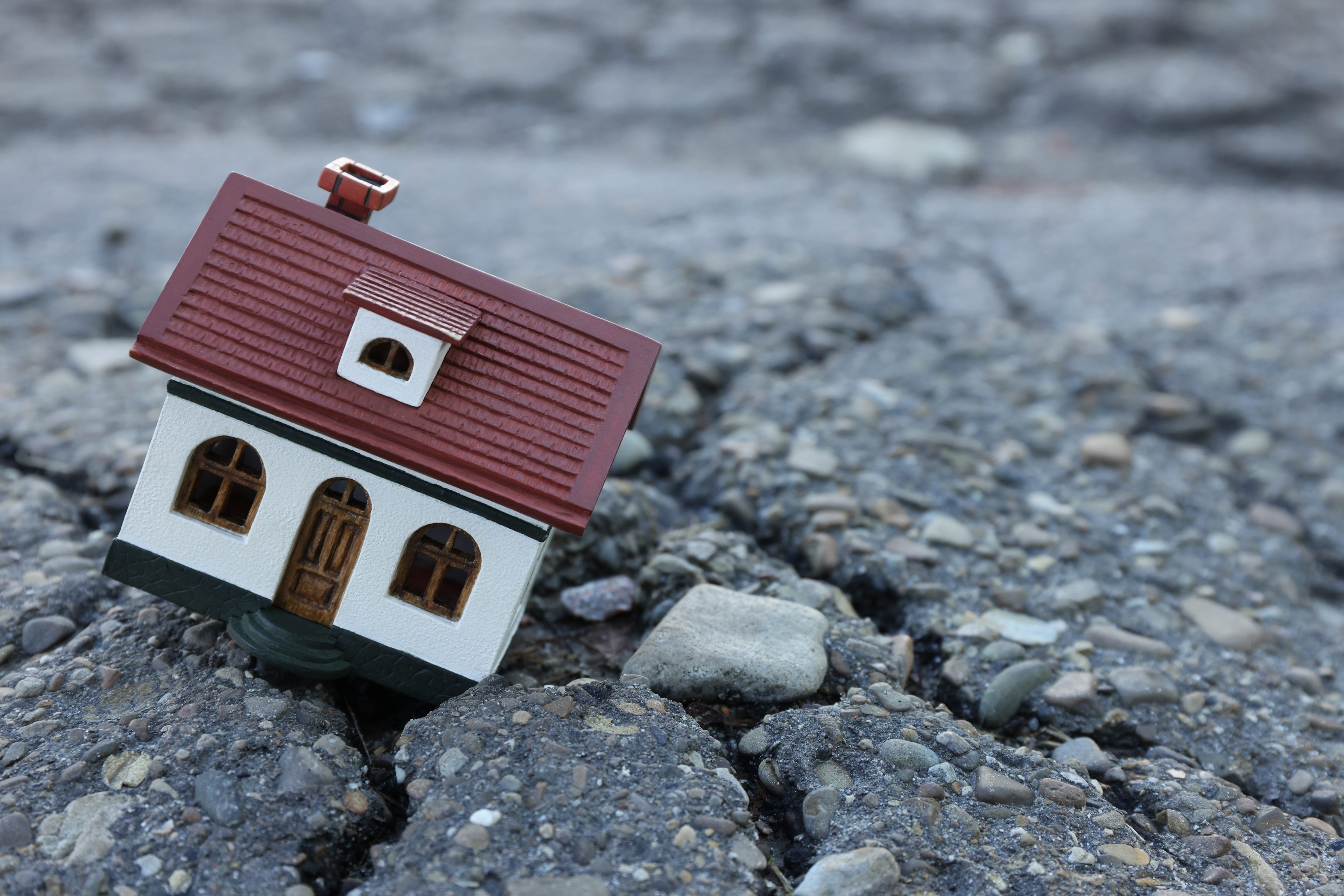 A model of a home on cracked round representing earthquake damage